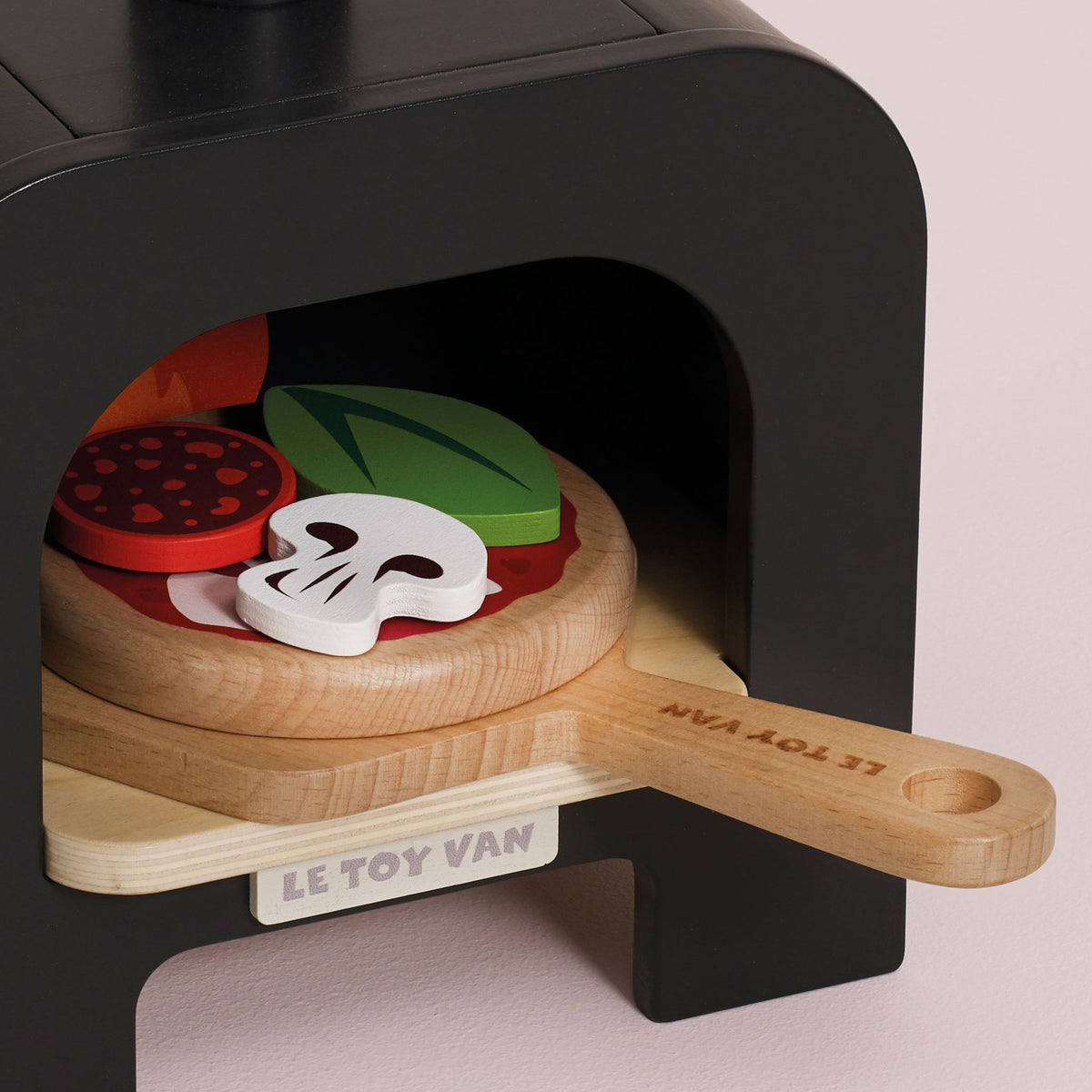 Toy pizza oven set with wooden peel and toy pizza ingredients, brand 'Le Toy Van' visible.