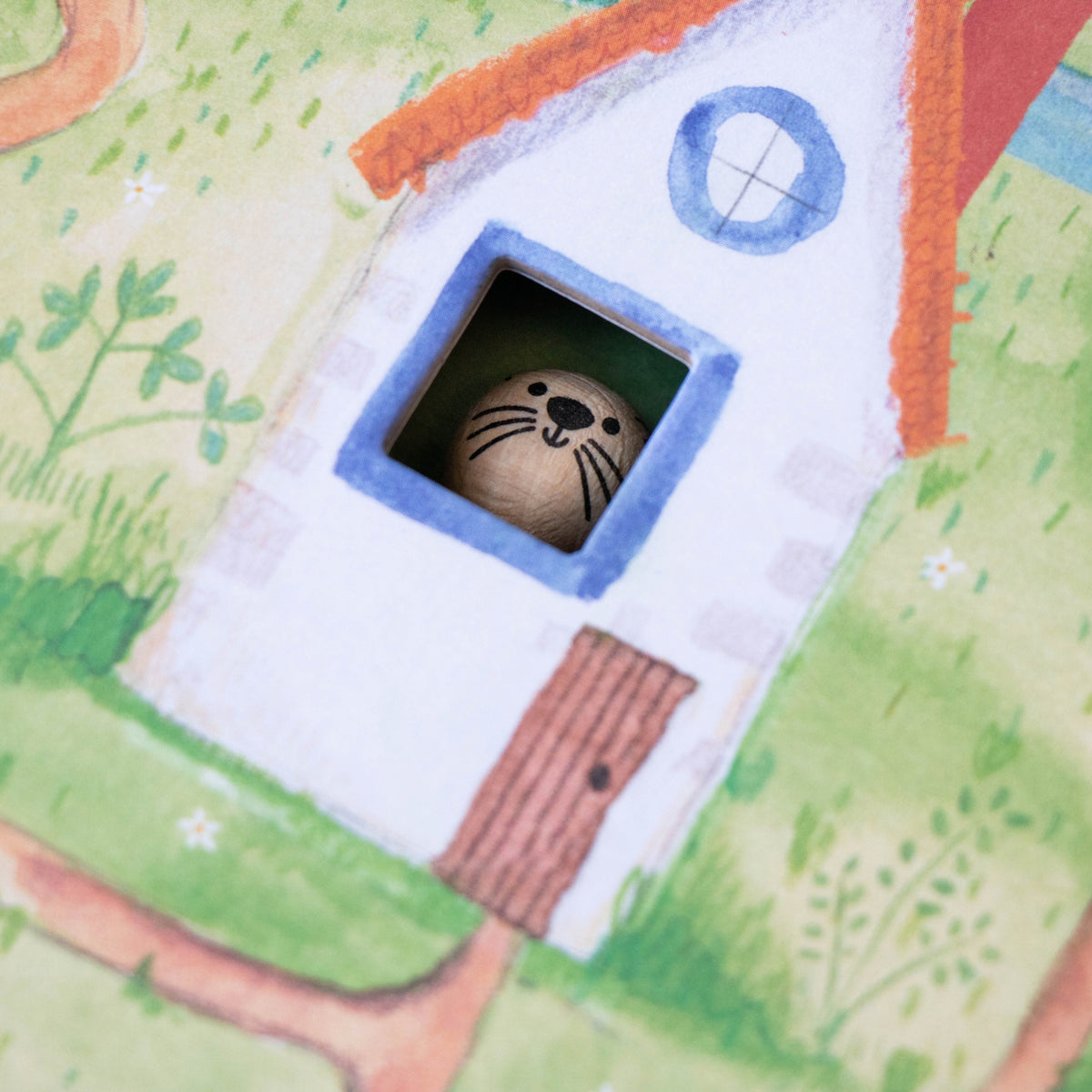 A close-up of a wooden toy otter visible from a small window-shaped opening on a colorful illustrated surface.