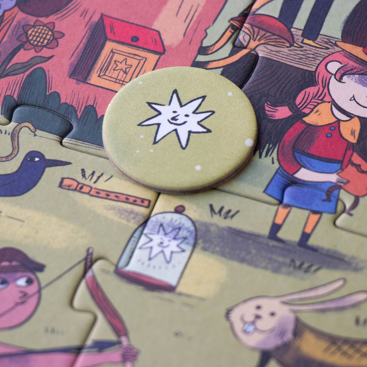 A close-up of a round token with a smiling star design, resting on a colorful illustrated jigsaw puzzle.