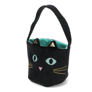 A black plush bucket bag designed to look like a cat's face, featuring embroidered light blue eyes, a pink nose, yellow whiskers, and a teal interior lining with gold triangular ear accents, set against a plain white background.